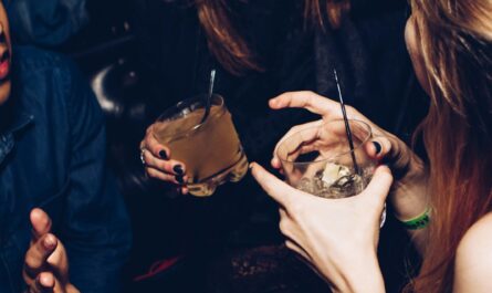 two women talking while holding drinking glasses